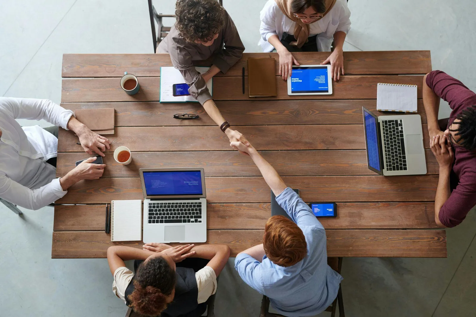 Business team collaborating with laptops and tablets, representing managed IT services and IT support for businesses.